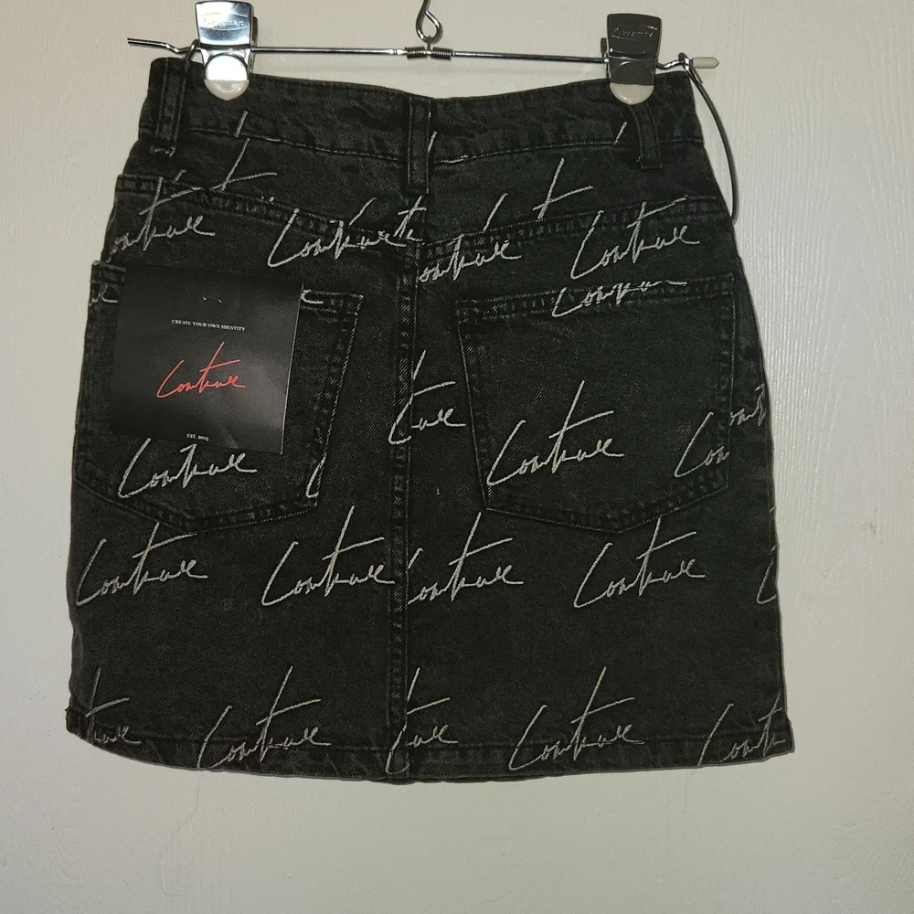 The couture Club Embroidery washed out black Jean Skirt. Size S.